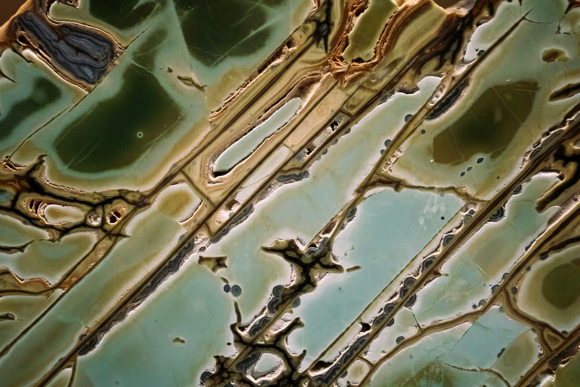 lapidary trim saw cutting a rough agate slab with water spray
