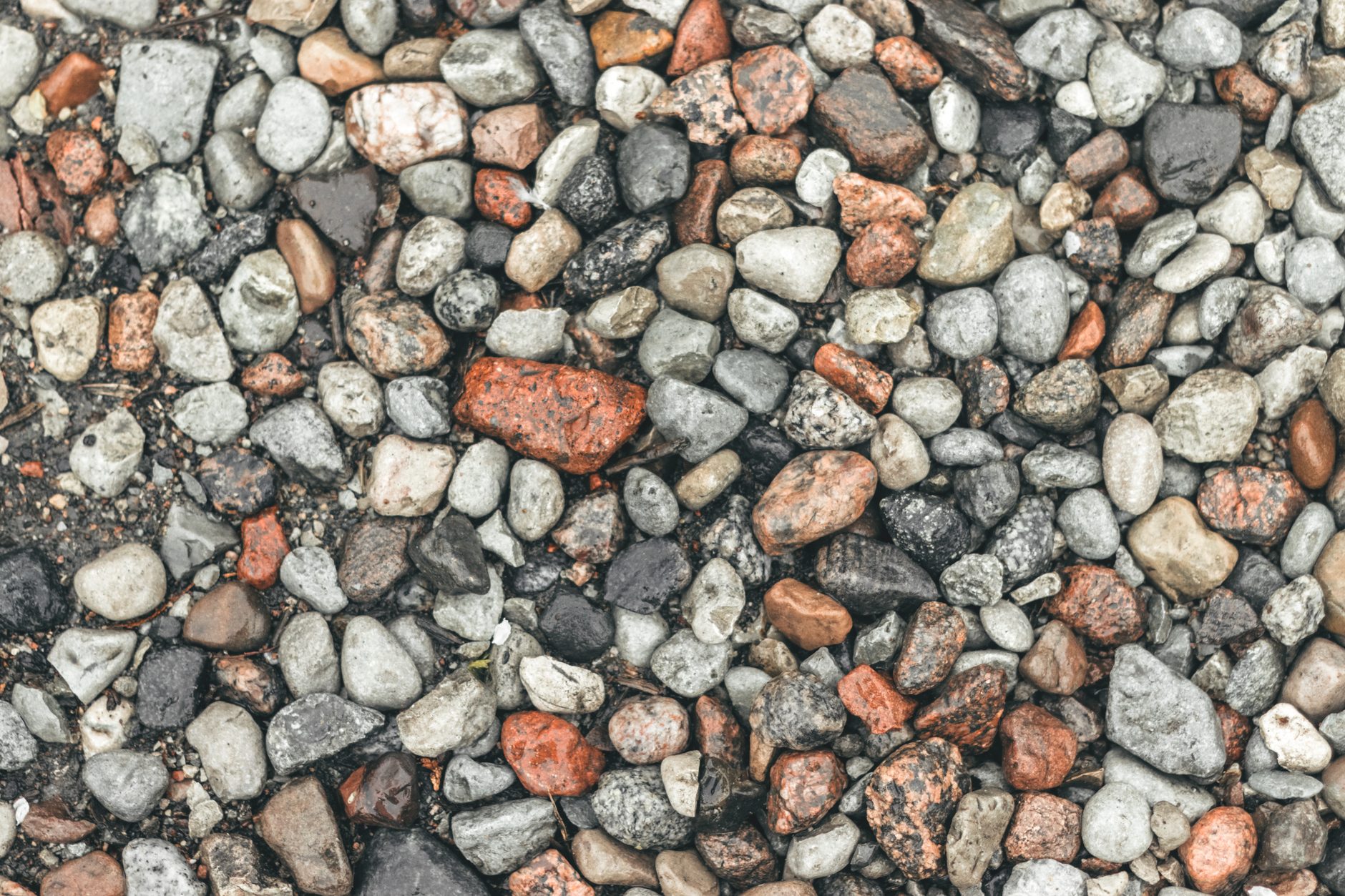 Lortone 3A rotary rock tumbler with rough stones beside a small pile of agates