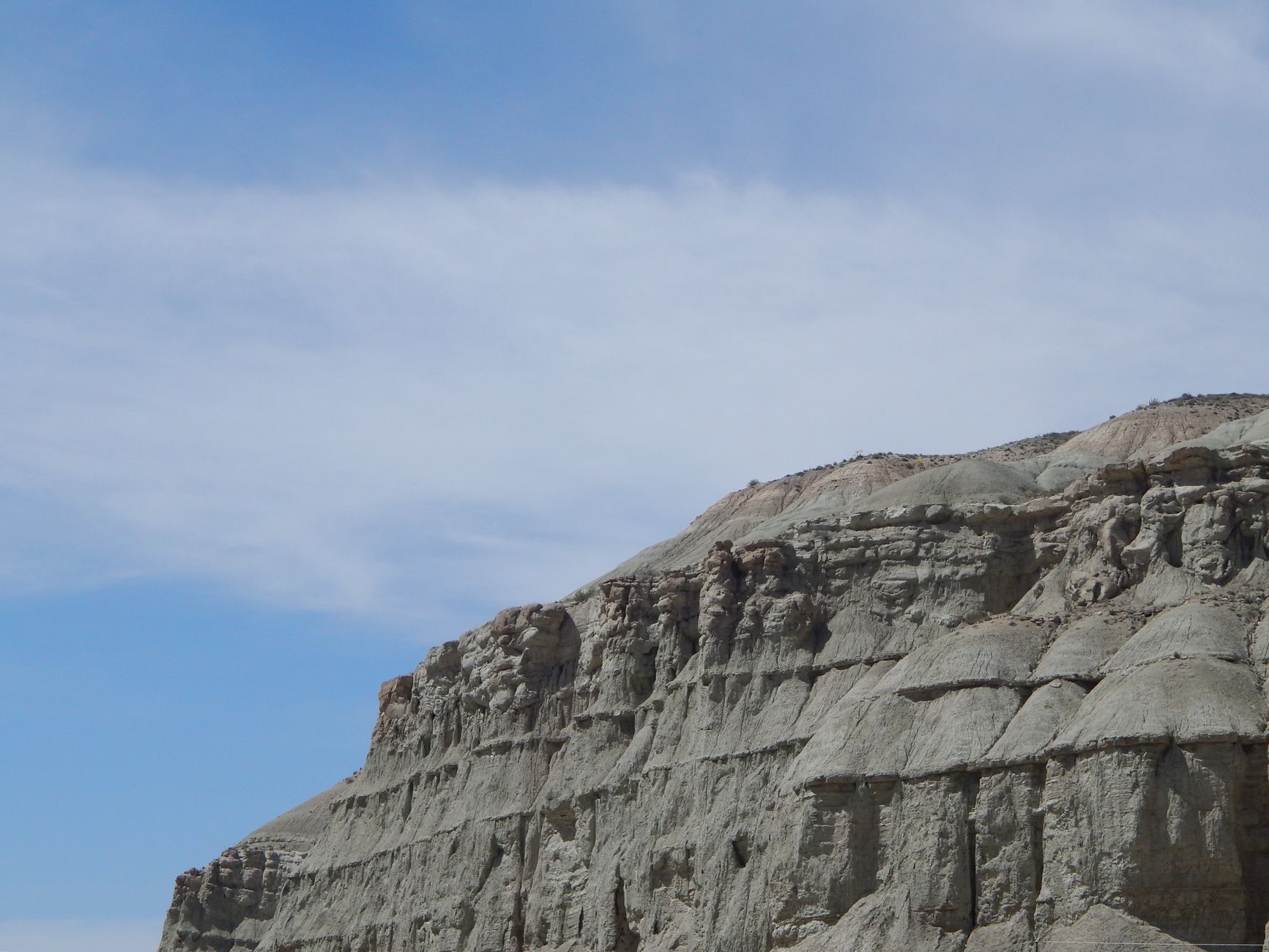 Stunning view of eroded rock formation against a bright blue sky, showcasing natural beauty.