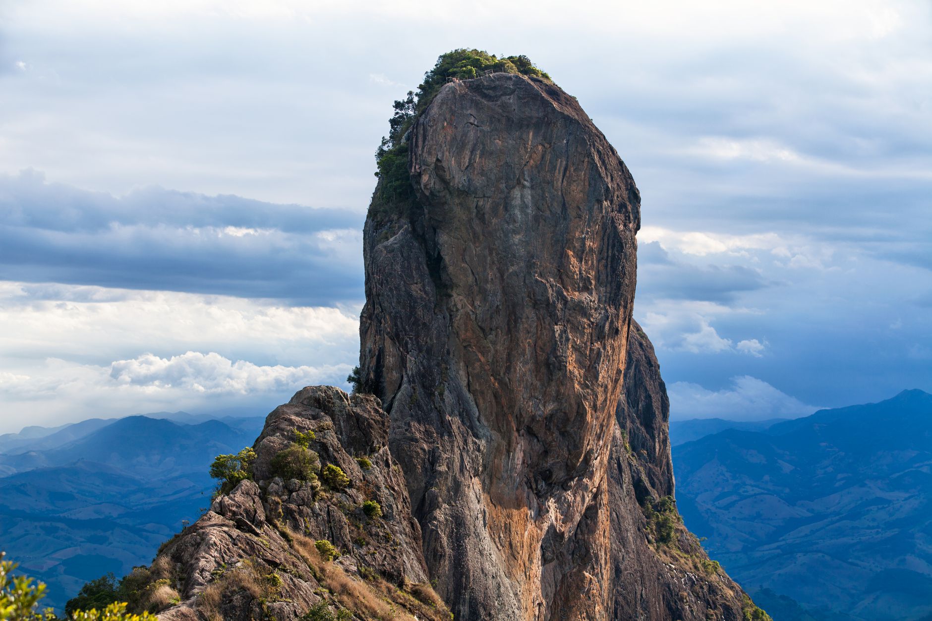 Dramatic rocky mountain peak surrounded by clouds, showcasing nature's grandeur.