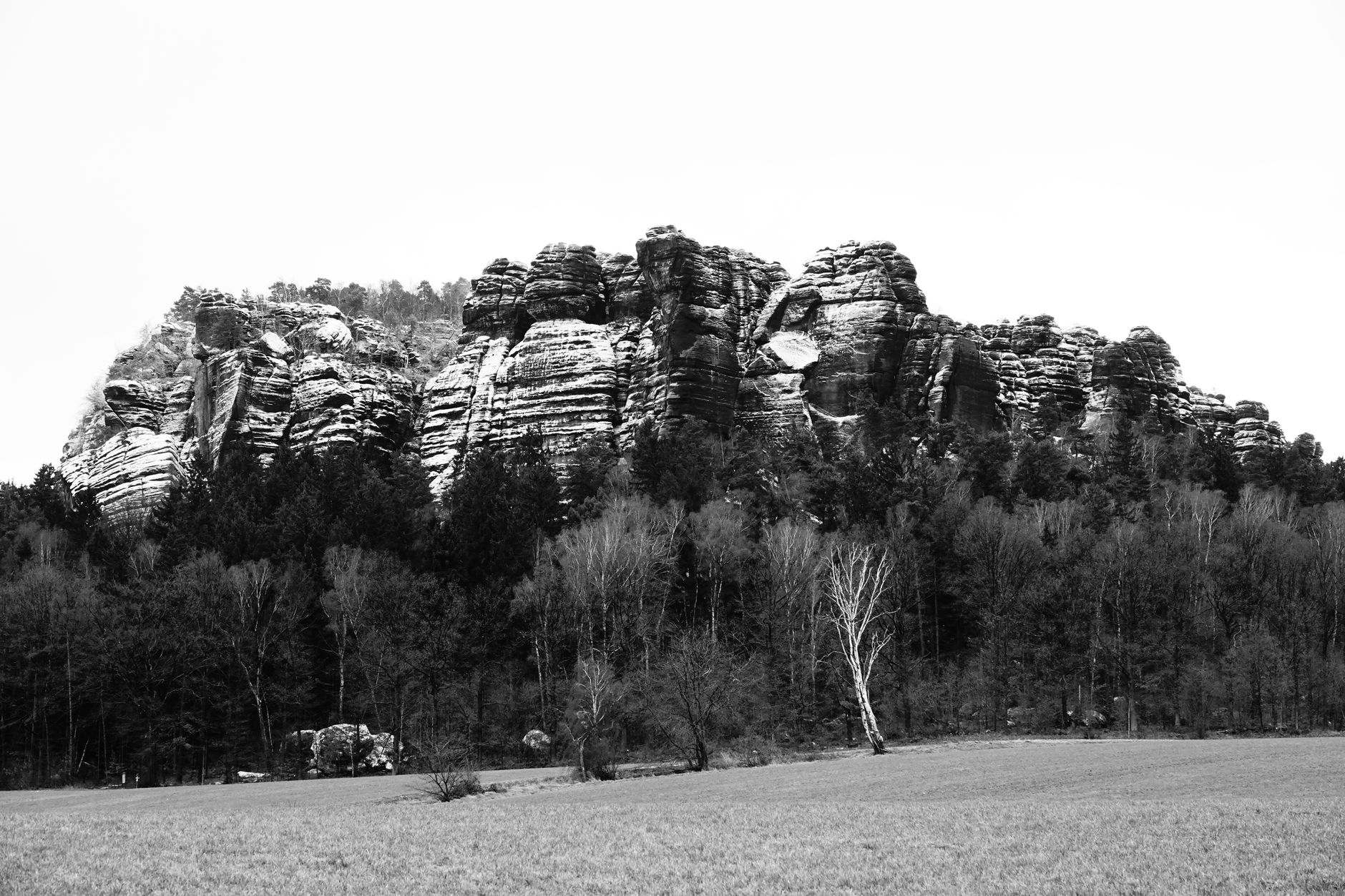Black and white photograph of Königstein's striking sandstone formations in Sachsen, Germany.