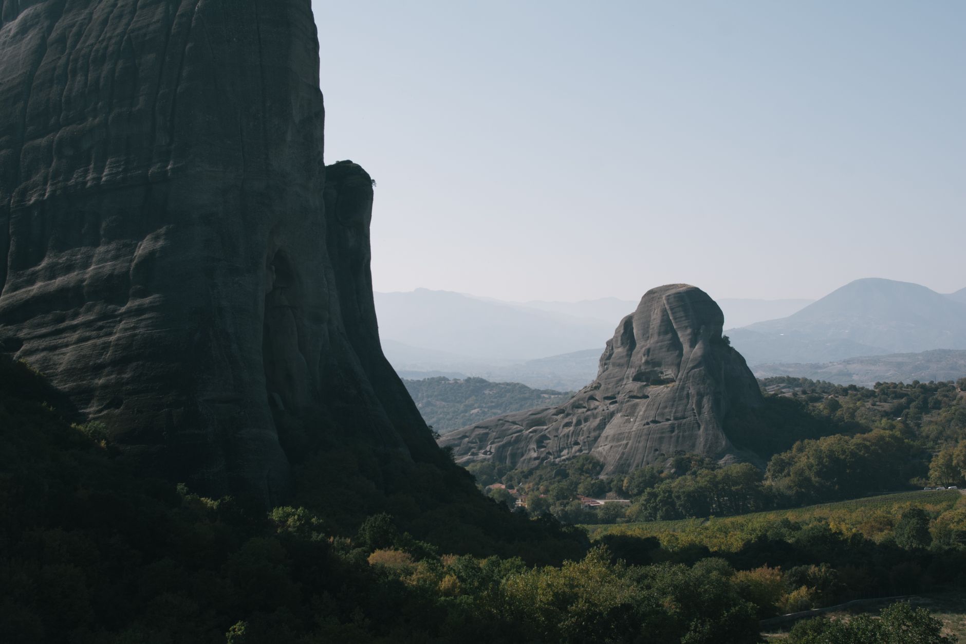 Majestic rock formations in Meteora, Greece, under clear skies, showcasing nature's beauty.