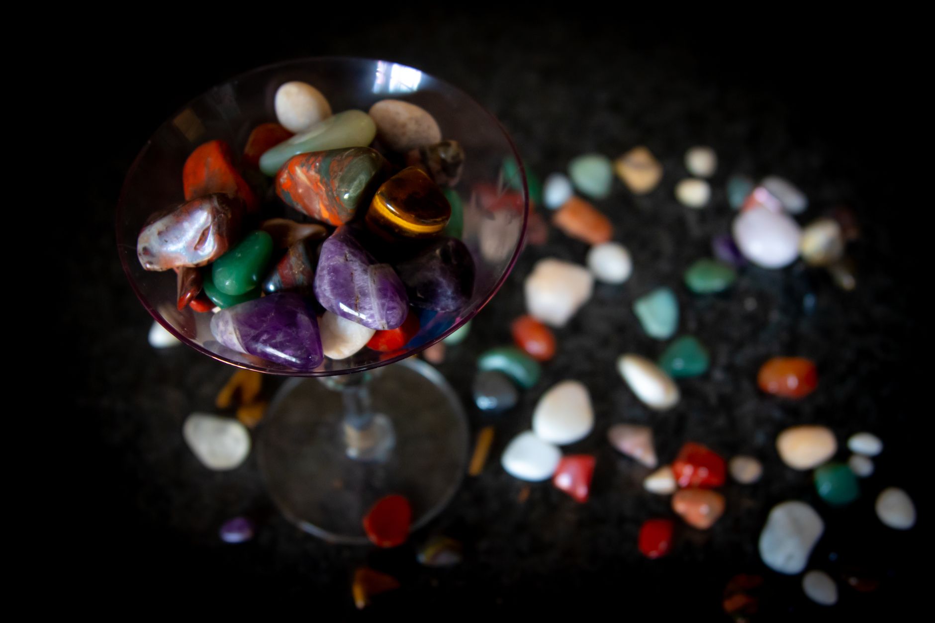 Close-up of vibrant semi-precious stones arranged inside a wine glass.