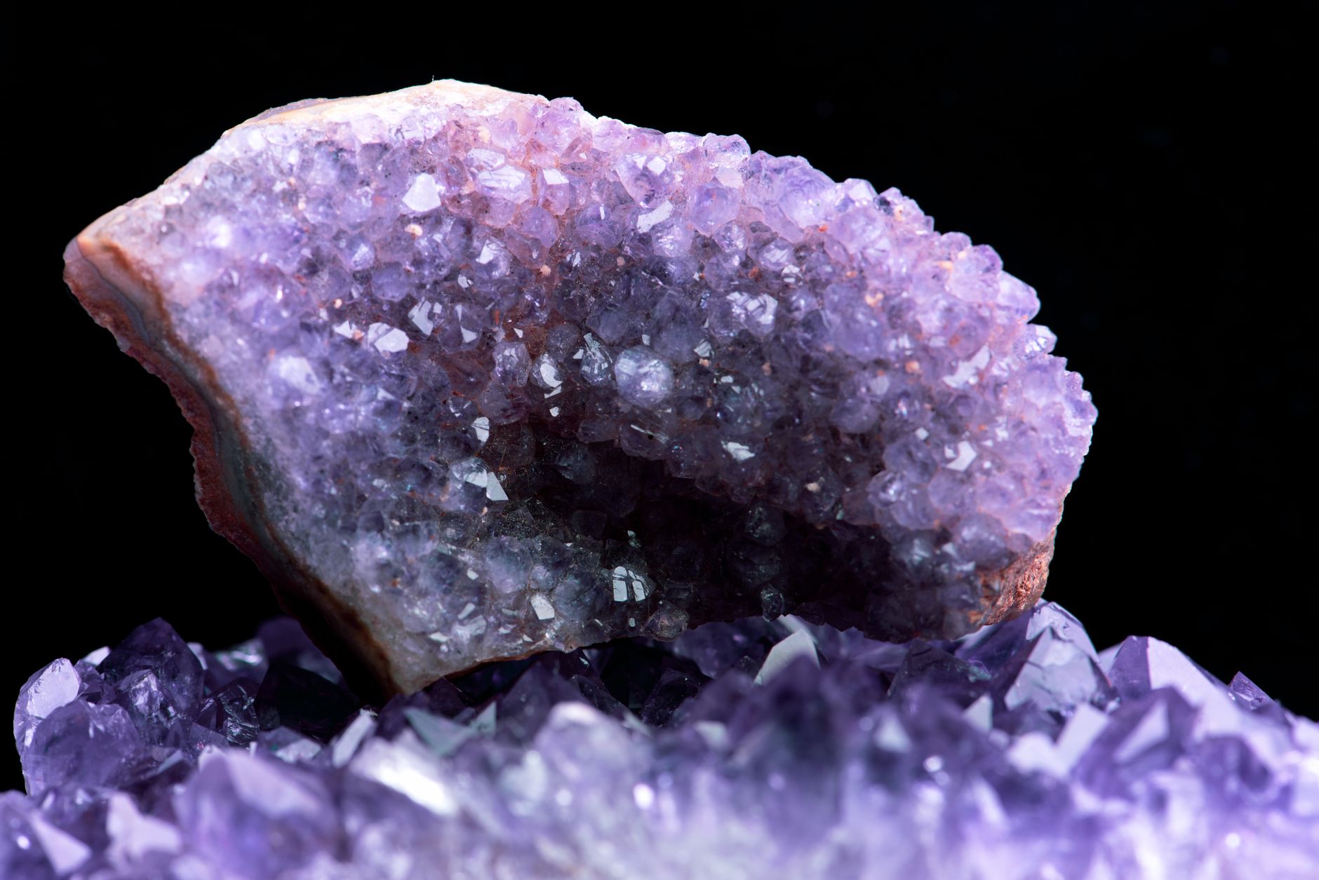 a cluster of raw quartz crystals sitting on a rocky surface