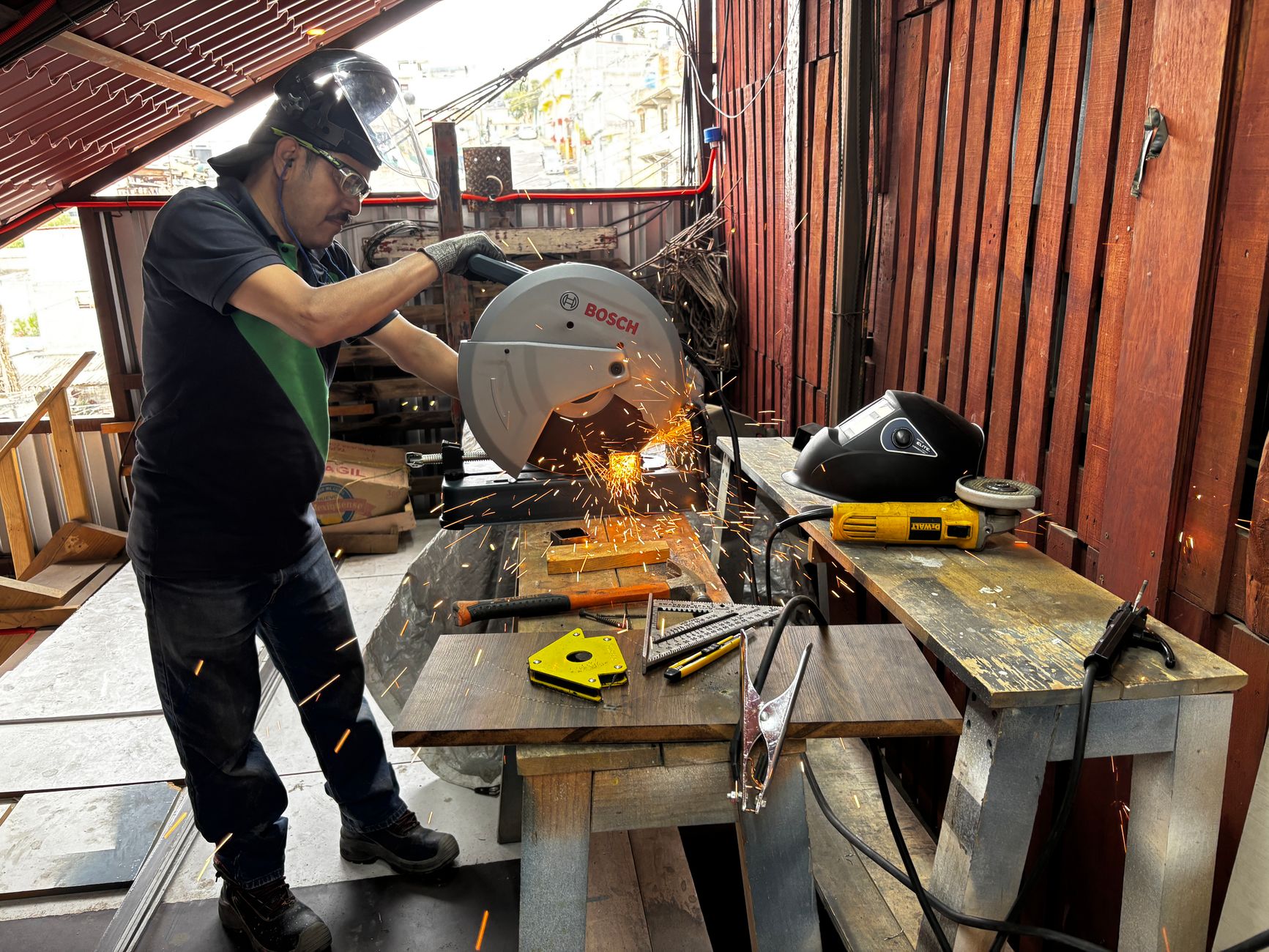 a wet tile saw on a workbench with safety glasses and gloves nearby