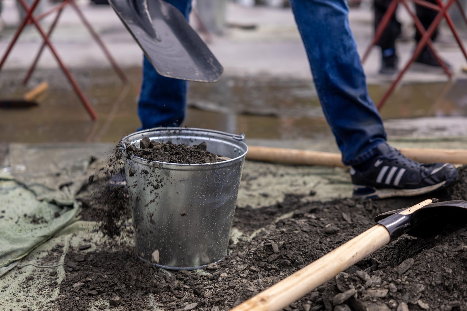 a sifting screen, shovel and bucket on a sandy river sandbar