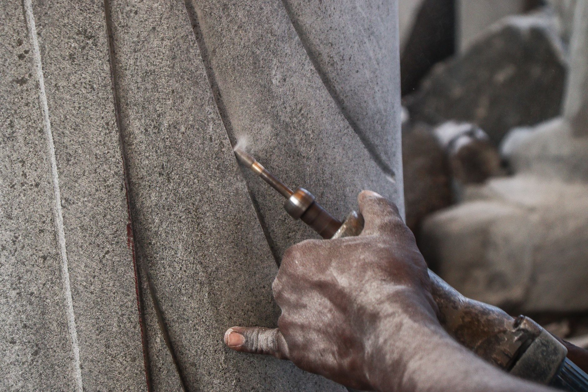 rock hammer, chisels, and gloves on rocky desert ground